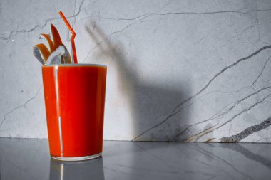 Taze portakal suyu gri bir arkaplanda izole edilmiş..