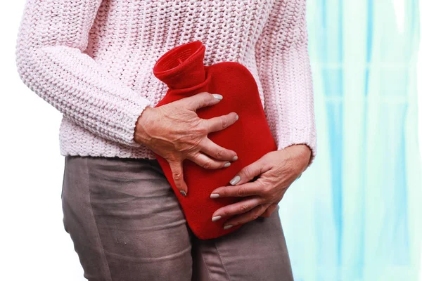 Mogen kvinna med varm flaska och cystit — Stockfoto