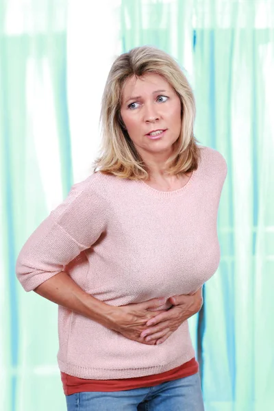 Mature woman with pain in her tummy — Stock Photo, Image