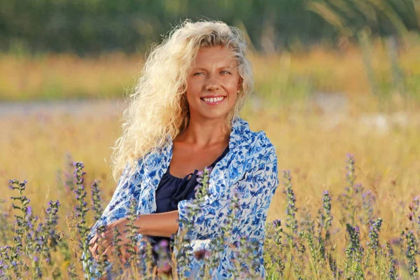 Happy mature woman relaxing in the meadow — Stock Photo, Image
