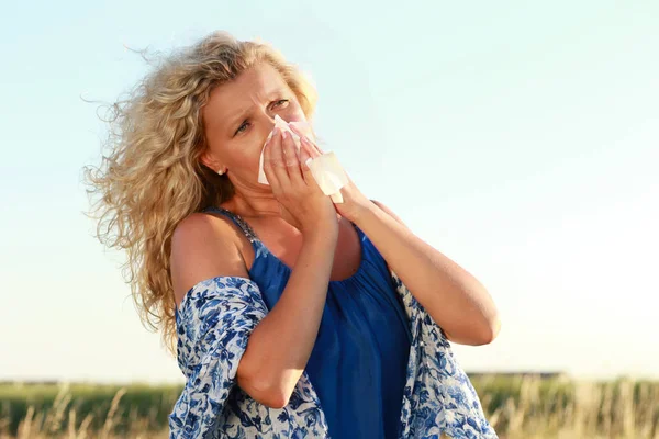 ハンカチを持つ成熟した女性が彼女の鼻を吹く — ストック写真