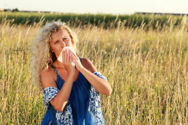 Mature woman with handkerchief blows her nose — Stock Photo, Image