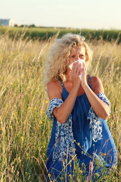 Mature woman with handkerchief blows her nose — Stock Photo, Image