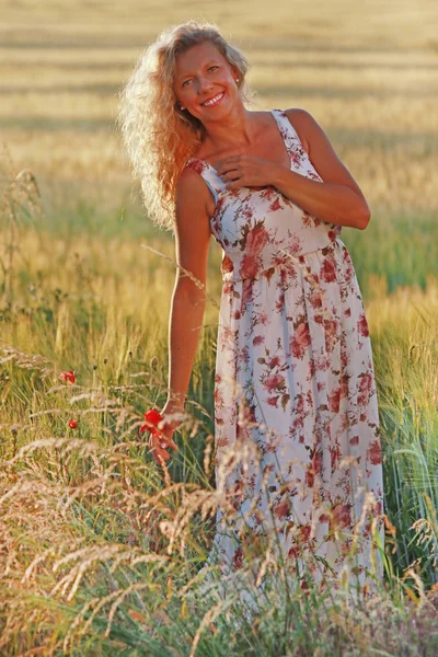 Счастливая зрелая женщина с длинным платьем в летний вечер — стоковое фото