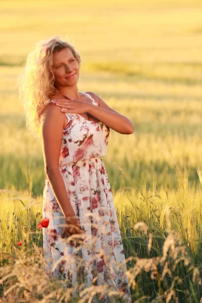 Glückliche reife Frau mit einem langen Kleid im Sommerabend — Stockfoto