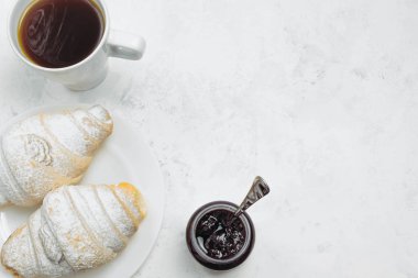 Kahvaltı taze hamur işleri, kruvasanla kahve ve polisle reçel.