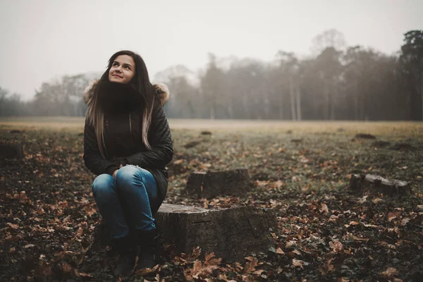 Молодая женщина сидит ствол дерева — стоковое фото