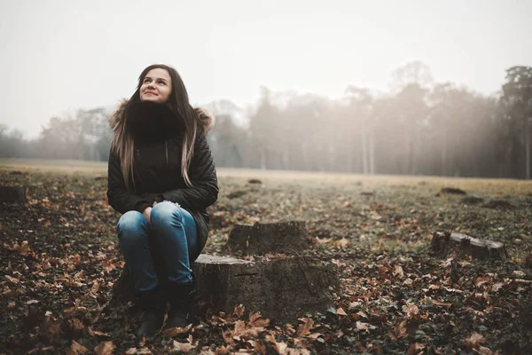 Молодая женщина сидит ствол дерева — стоковое фото