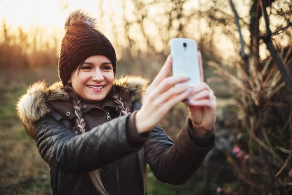 Mujer atractiva joven tomando fotos con teléfono inteligente — Foto de Stock