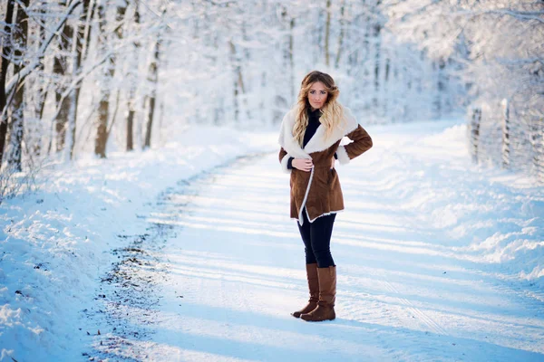 Portrait de jeune femme blonde sur la route forestière d'hiver — Photo