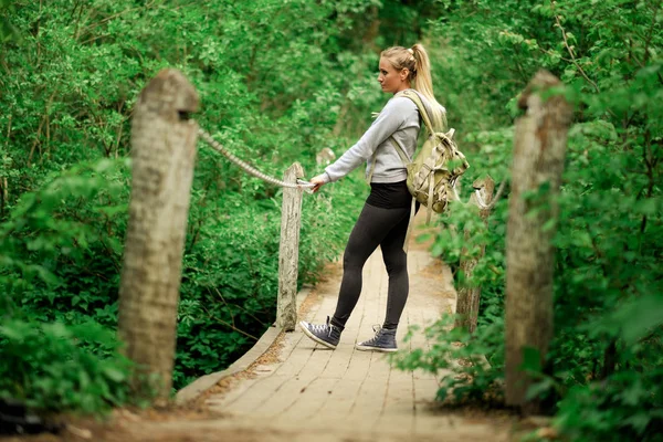 Пішохідна жінка на лісовому мосту — стокове фото