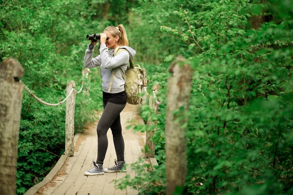 Mujer exploradora bonita con prismáticos — Foto de Stock