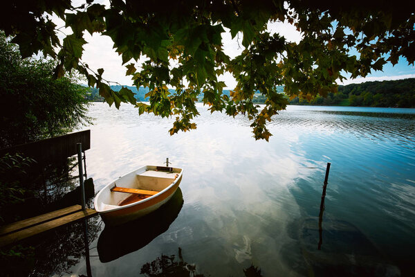 Peaceful atmosphere lake,boats and pier