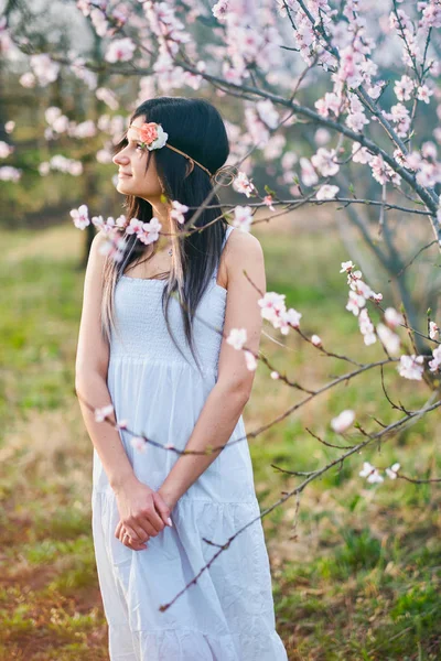 Linda mujer joven con el árbol en flor — Foto de Stock