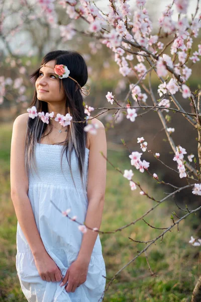 Милая молодая женщина с цветущим деревом — стоковое фото