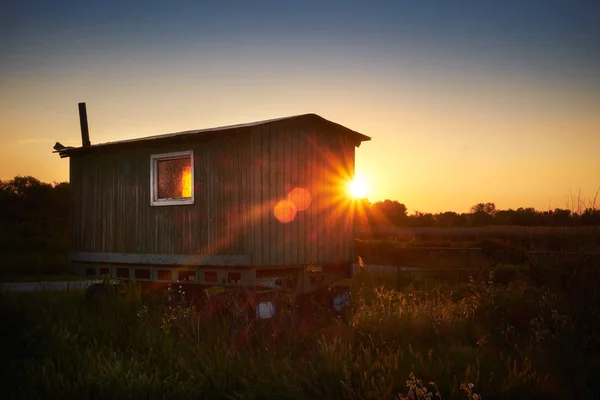 Starý karavan na poli krajiny sunset — Stock fotografie