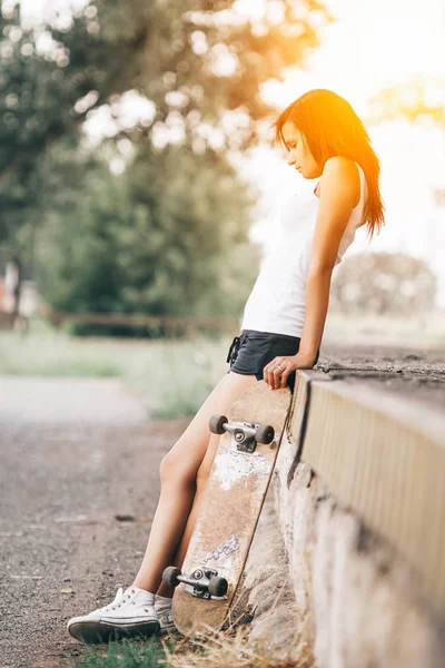 Beautiful skater girl in summer city — Stock Photo, Image