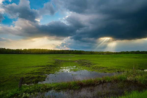 Raios de sol sobre o campo tempestuoso — Fotografia de Stock