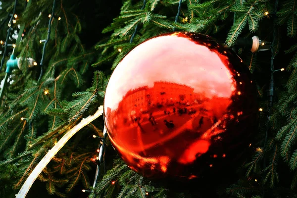 Gran árbol de Navidad rojo bola de cristal decoración con reflejo de la plaza de la ciudad — Foto de Stock