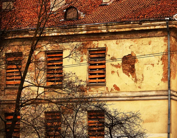 Antiguo edificio con tablón de madera tapiado ventanas — Foto de Stock