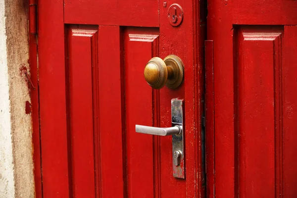 Κόκκινη ξύλινη πόρτα με στρογγυλή περίτεχνη λαβή και παραδοσιακή λαβή — Φωτογραφία Αρχείου