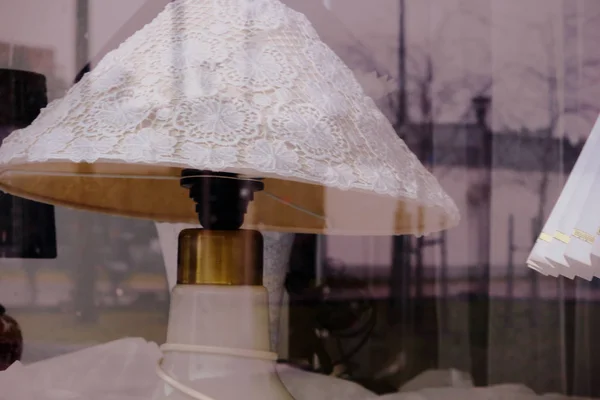 Weiße Lampe mit Spitzenschirm hinter einem Fensterglas — Stockfoto