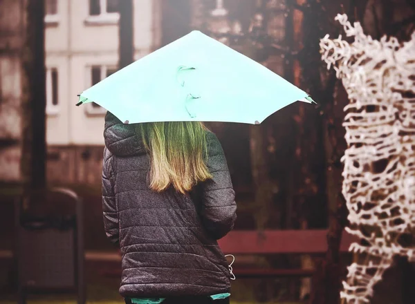 Ragazza con lunghi capelli biondi che cammina sotto un luminoso ombrello ciano — Foto Stock