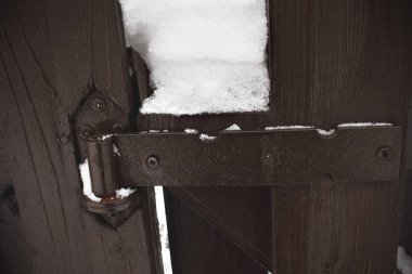 Metal clasp on brown wooden plan fence