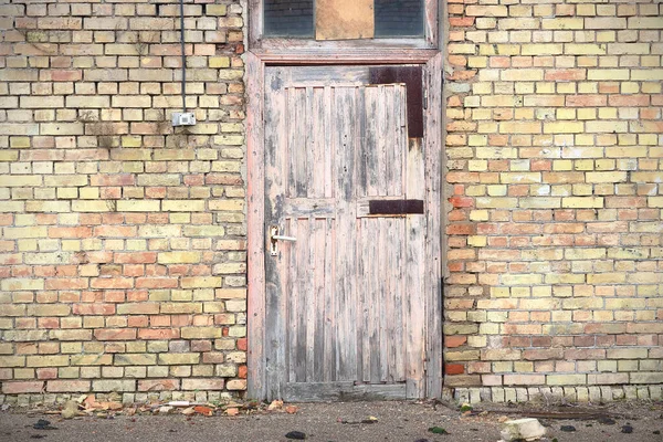 Roze houten deur in geel bakstenen muurgebouw — Stockfoto