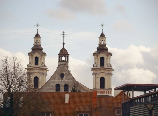 教会はヨーロッパ リトアニアの赤い家の屋根を渡ります — ストック写真