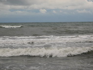 İnişli çıkışlı bir dalga ile günbatımı bir gökyüzü Beach günbatımı mı
