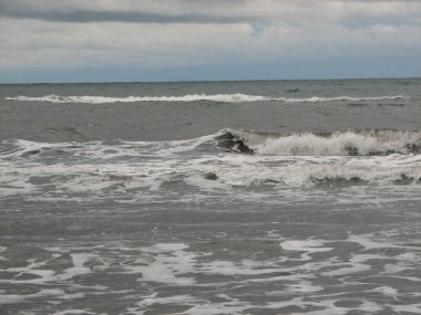 İnişli çıkışlı bir dalga ile günbatımı bir gökyüzü Beach günbatımı mı