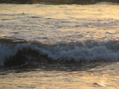 İnişli çıkışlı bir dalga ile günbatımı bir gökyüzü Beach günbatımı mı