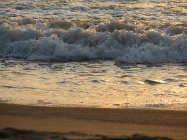 İnişli çıkışlı bir dalga ile günbatımı bir gökyüzü Beach günbatımı mı