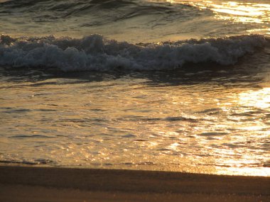 İnişli çıkışlı bir dalga ile günbatımı bir gökyüzü Beach günbatımı mı