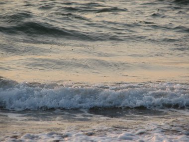 İnişli çıkışlı bir dalga ile günbatımı bir gökyüzü Beach günbatımı mı