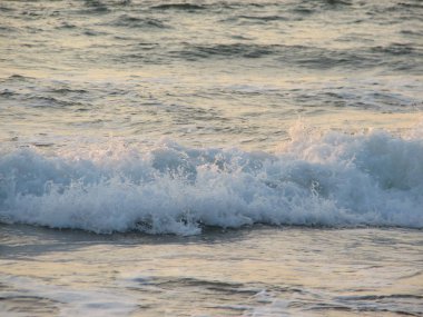 İnişli çıkışlı bir dalga ile günbatımı bir gökyüzü Beach günbatımı mı