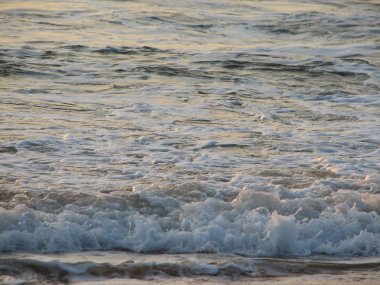 İnişli çıkışlı bir dalga ile günbatımı bir gökyüzü Beach günbatımı mı