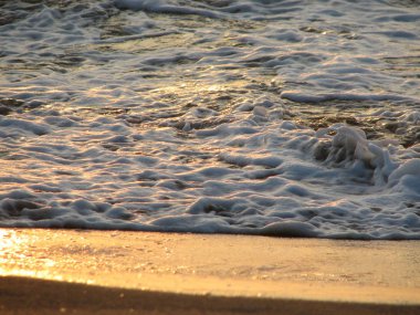 İnişli çıkışlı bir dalga ile günbatımı bir gökyüzü Beach günbatımı mı