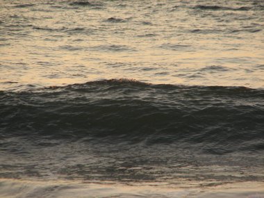 İnişli çıkışlı bir dalga ile günbatımı bir gökyüzü Beach günbatımı mı