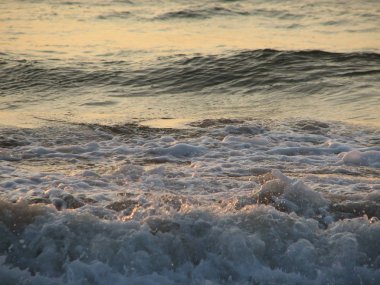 İnişli çıkışlı bir dalga ile günbatımı bir gökyüzü Beach günbatımı mı