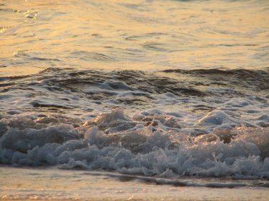 İnişli çıkışlı bir dalga ile günbatımı bir gökyüzü Beach günbatımı mı