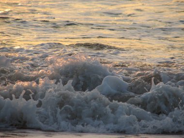 İnişli çıkışlı bir dalga ile günbatımı bir gökyüzü Beach günbatımı mı