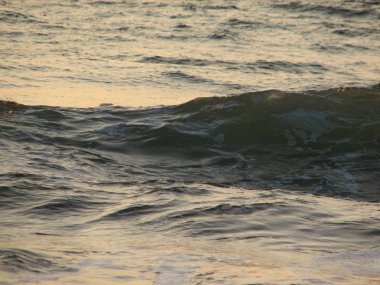 İnişli çıkışlı bir dalga ile günbatımı bir gökyüzü Beach günbatımı mı