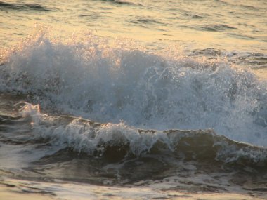 İnişli çıkışlı bir dalga ile günbatımı bir gökyüzü Beach günbatımı mı