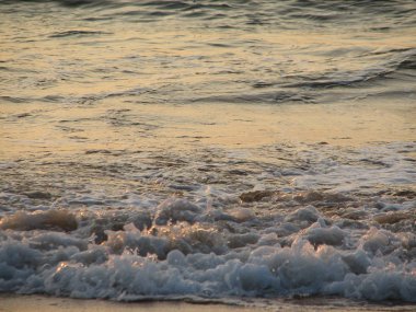 İnişli çıkışlı bir dalga ile günbatımı bir gökyüzü Beach günbatımı mı