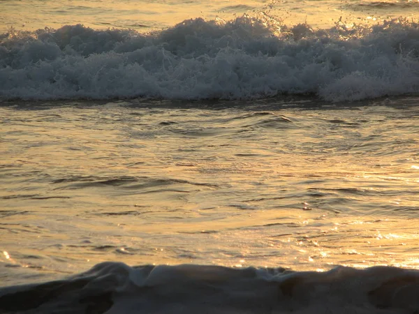Playa puesta de sol es un cielo puesta de sol con una ola rodando —  Fotos de Stock