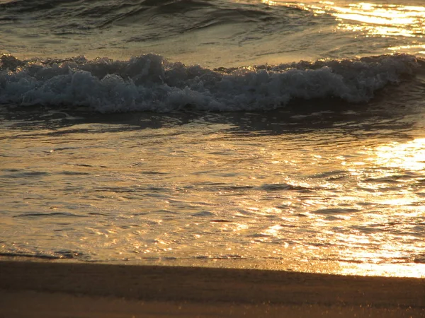 İnişli çıkışlı bir dalga ile günbatımı bir gökyüzü Beach günbatımı mı