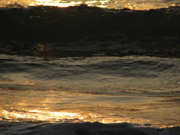 Coucher de soleil sur la plage est un ciel couchant avec une vague roulant — Photo