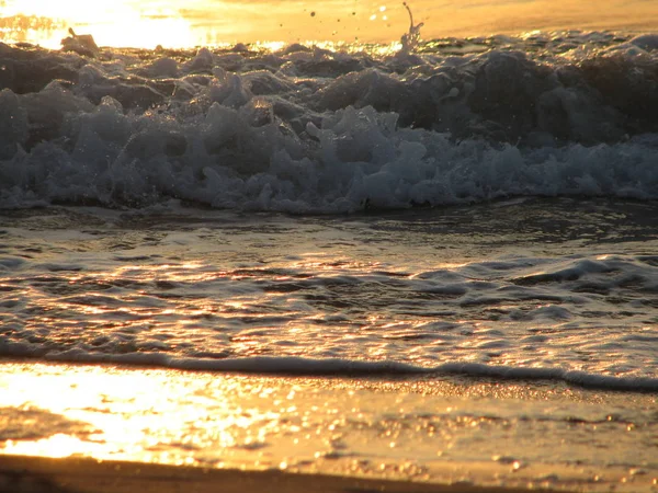 İnişli çıkışlı bir dalga ile günbatımı bir gökyüzü Beach günbatımı mı